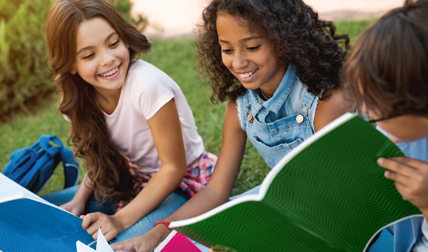 Middle school students reading outside