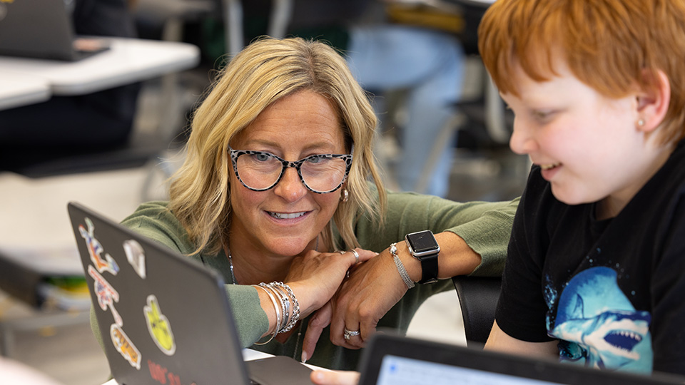 Teacher supporting student with AI learning