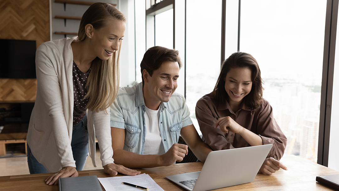 A group of teachers using a laptop